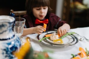 boy in red and white polka dot shirt eating