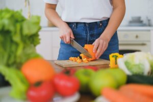 woman cutting vegetables on a cutting board