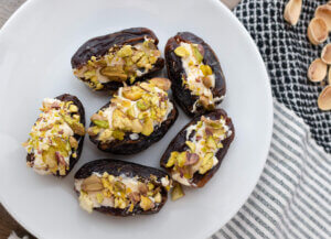 Stuffed dates with cream cheese on a white plate