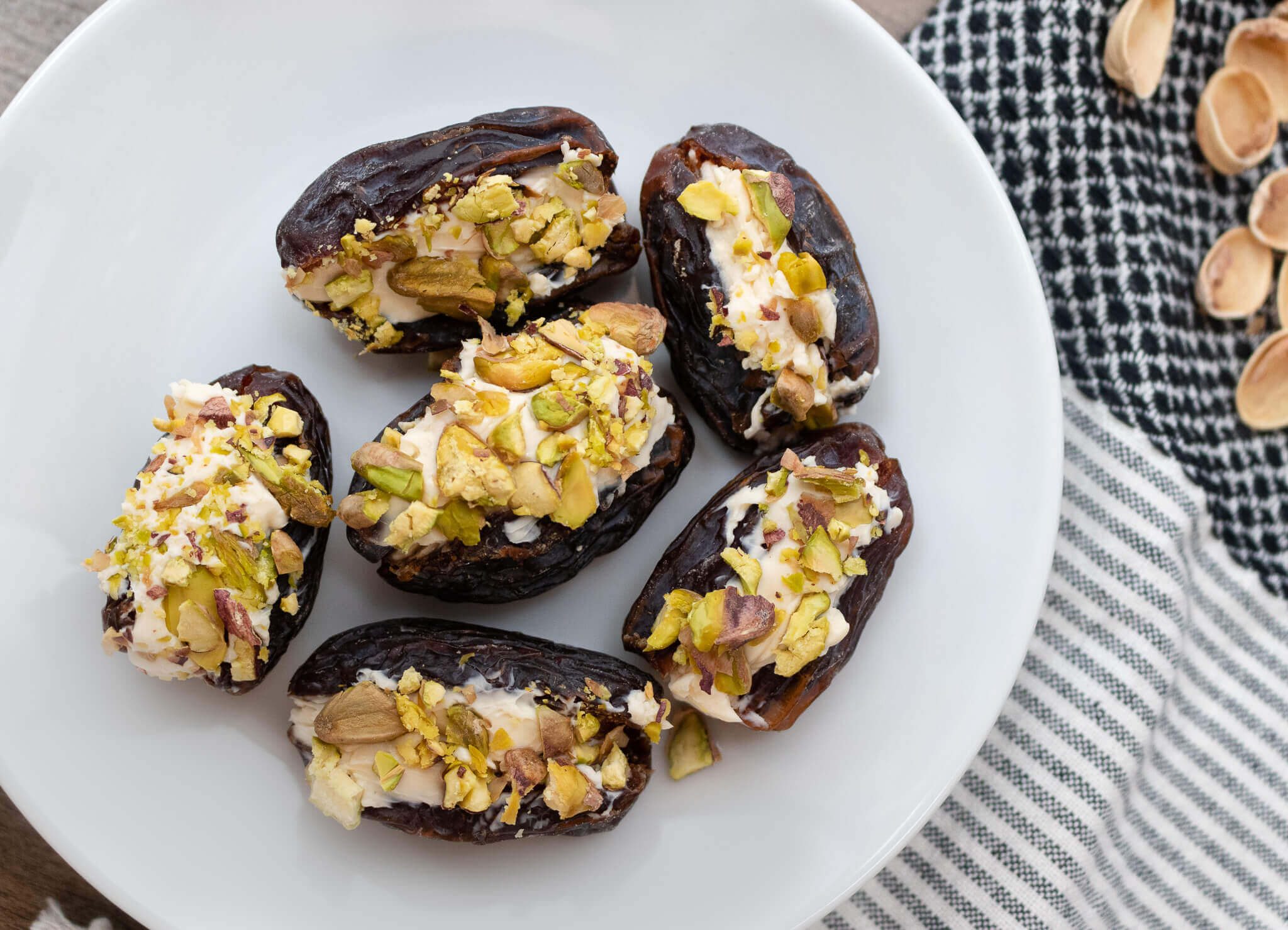 Stuffed dates with cream cheese on a white plate