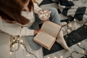 woman holding a book and a cup