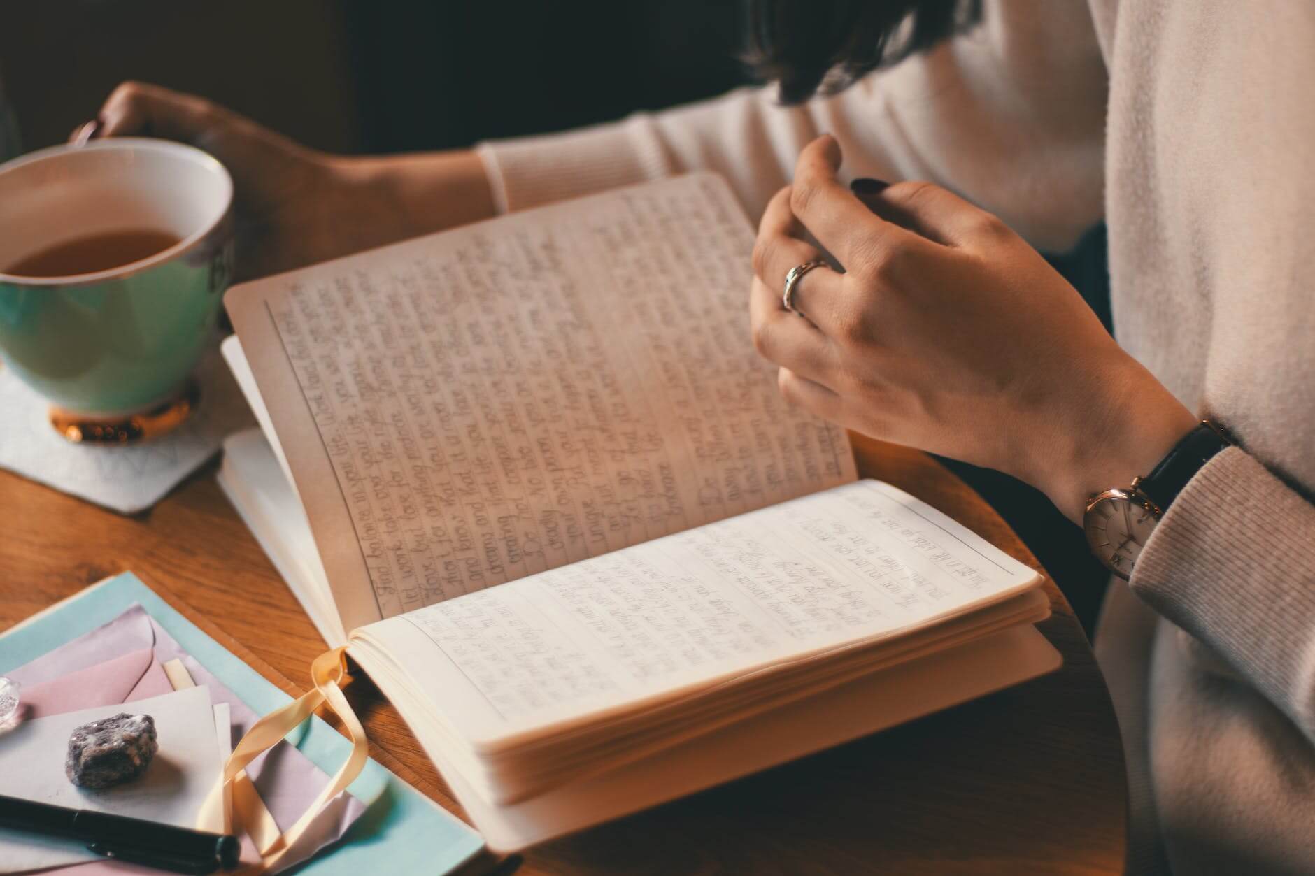 photo of person holding cup body positive journal prompts