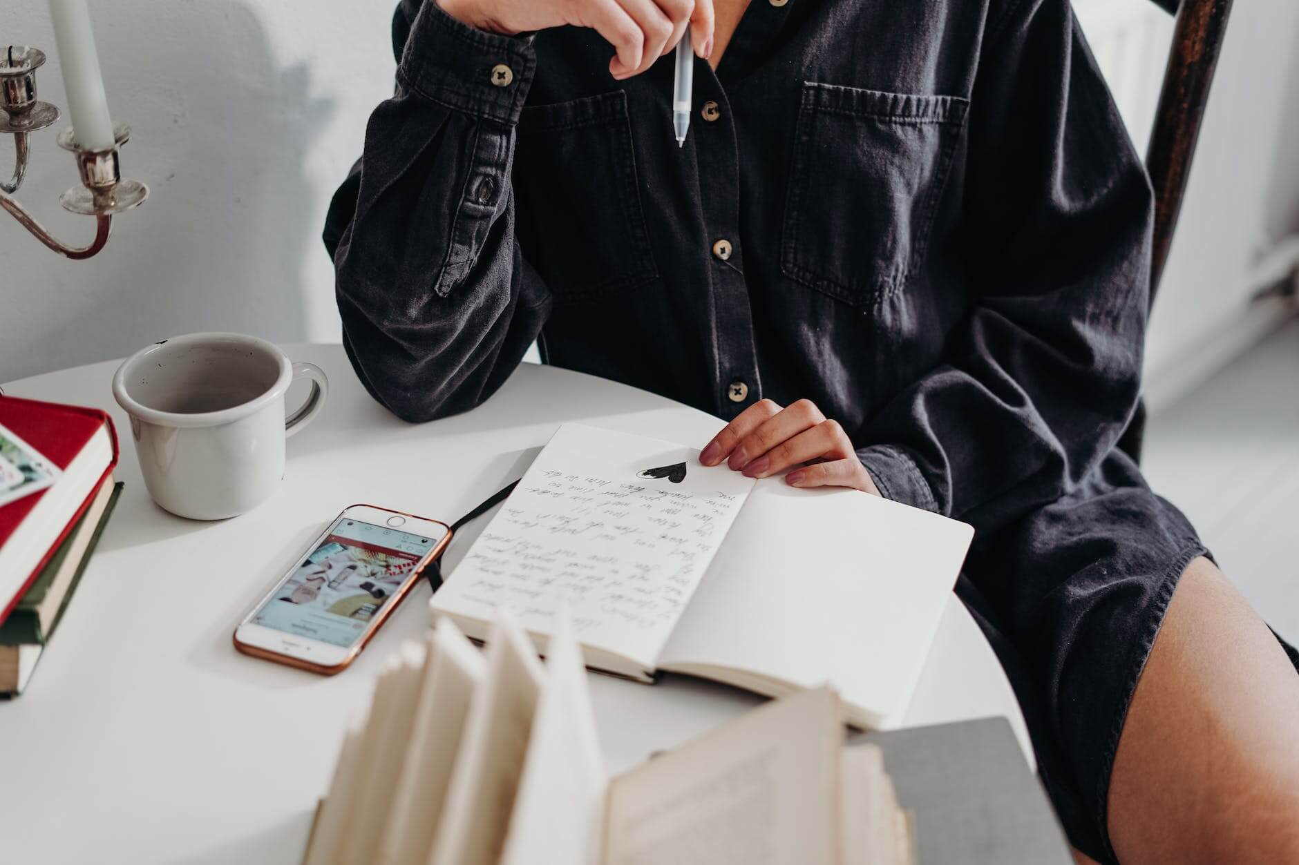 person sitting on wooden chair doing body positive journal prompts