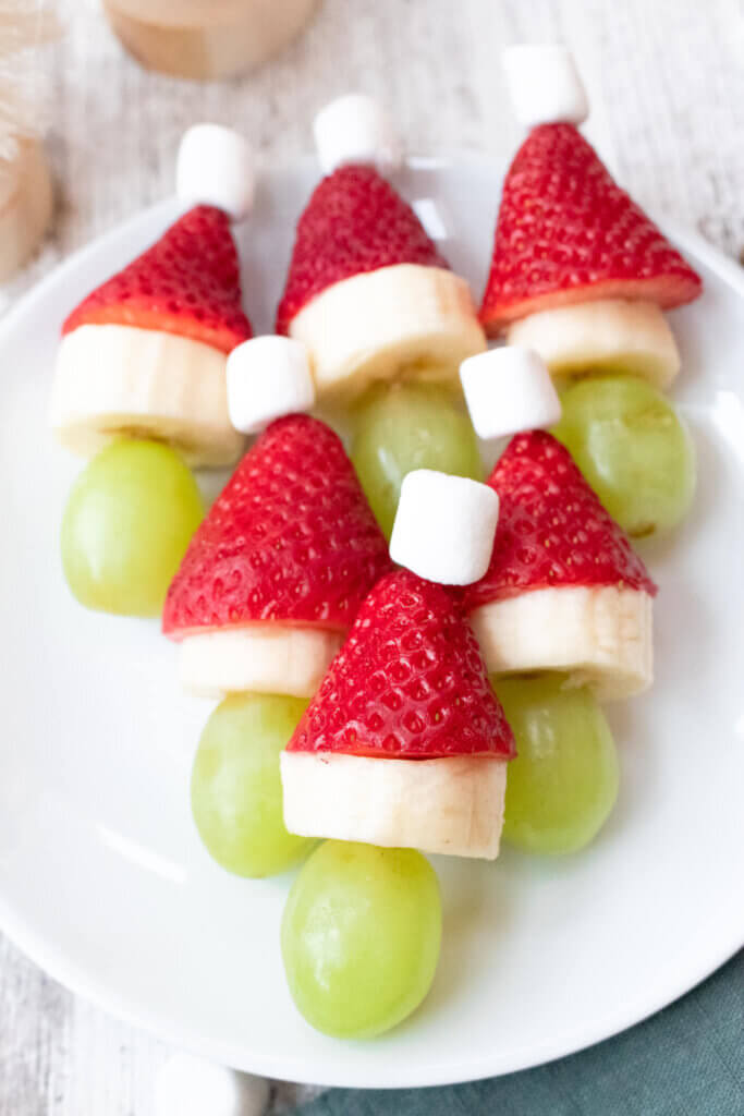 Grinch fruit kabobs on a white plate