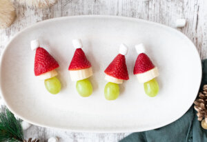 Healthy grinch fruit kabobs on a long plate