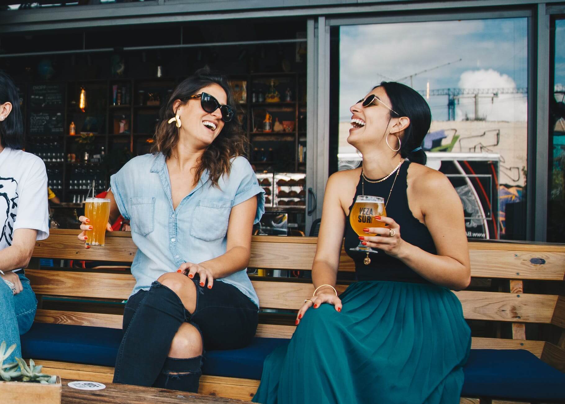 two smiling women sitting on wooden bench for dry January