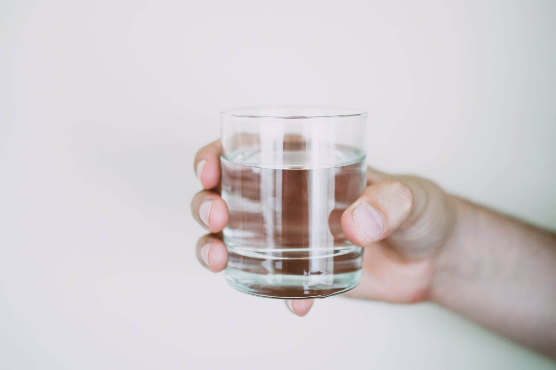 person holding drinking glass of water