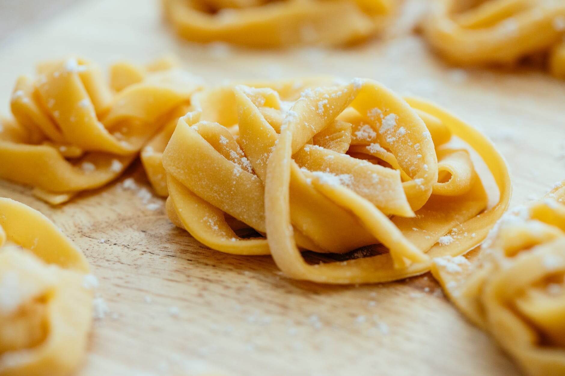 homemade long noodles made with egg dough on table