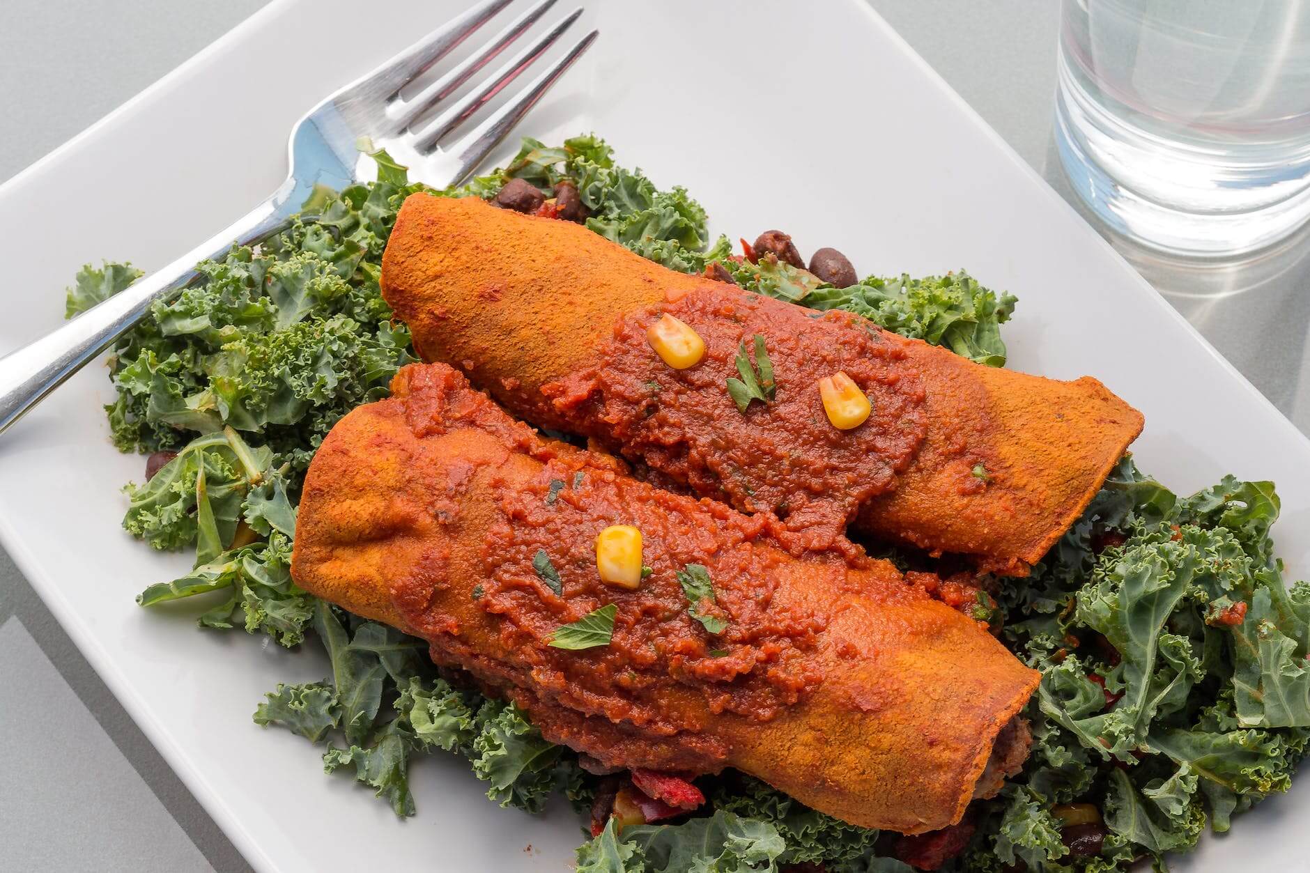 enchiladas with sauce served on kale