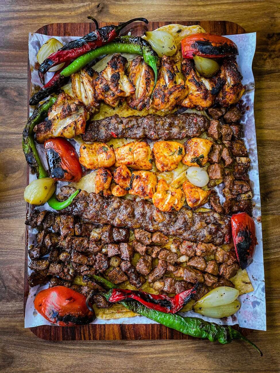 a mix of grilled meat with red and green peppers and tomatoes