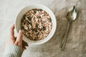 person holding bowl full of oats