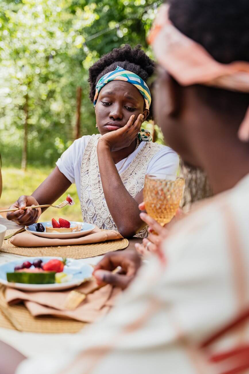 bored woman sitting at a table with food