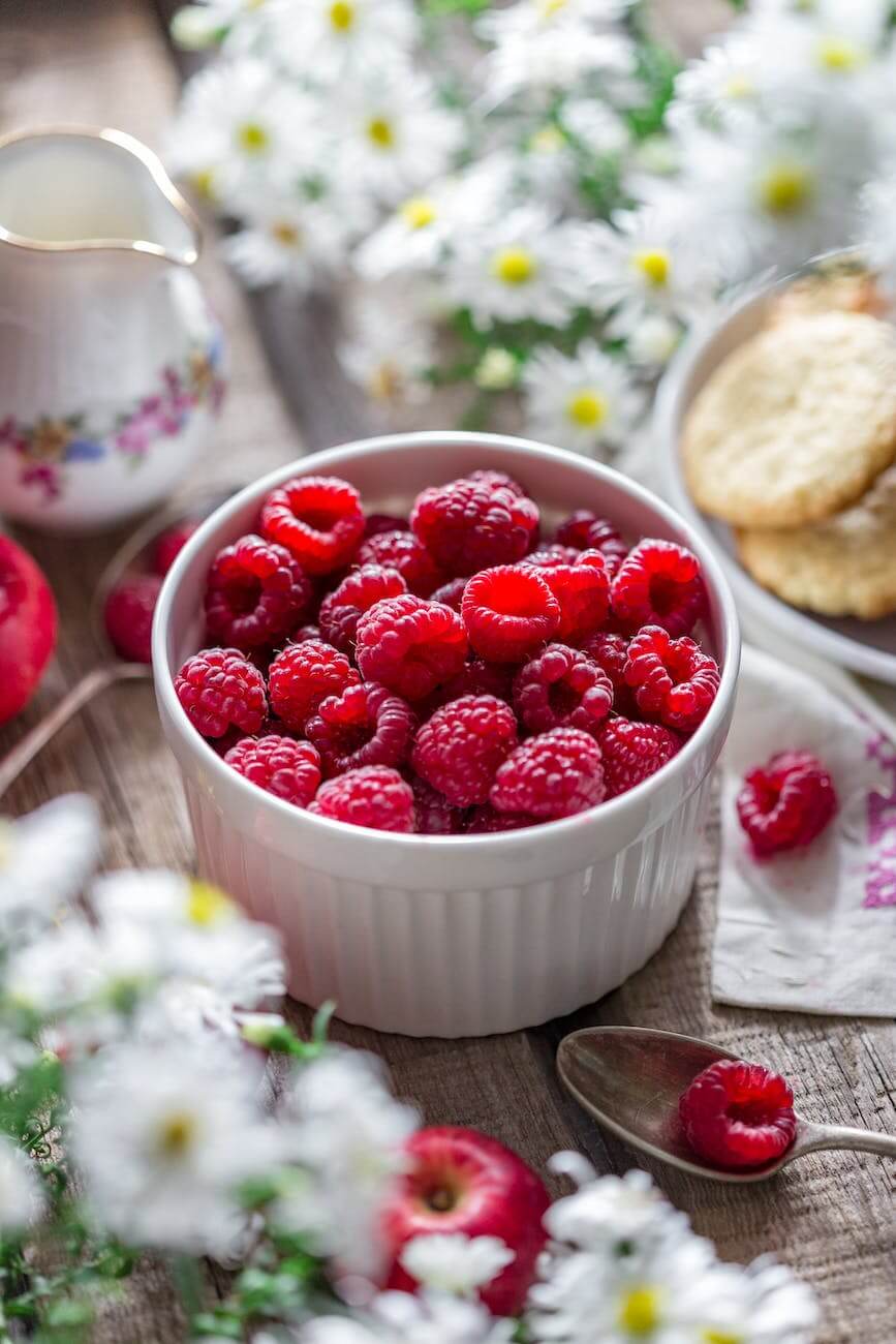 close up of raspberries in bowl on table