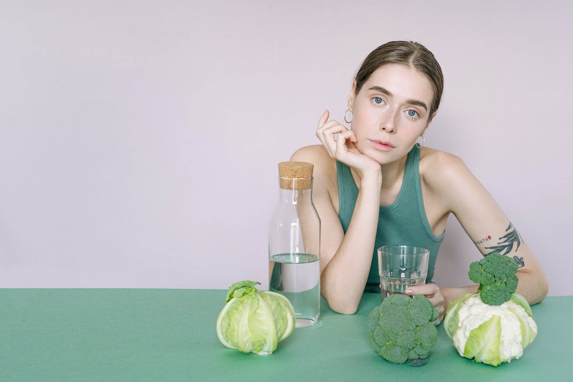 woman in green tank top sitting on green table trying to ditch dieting