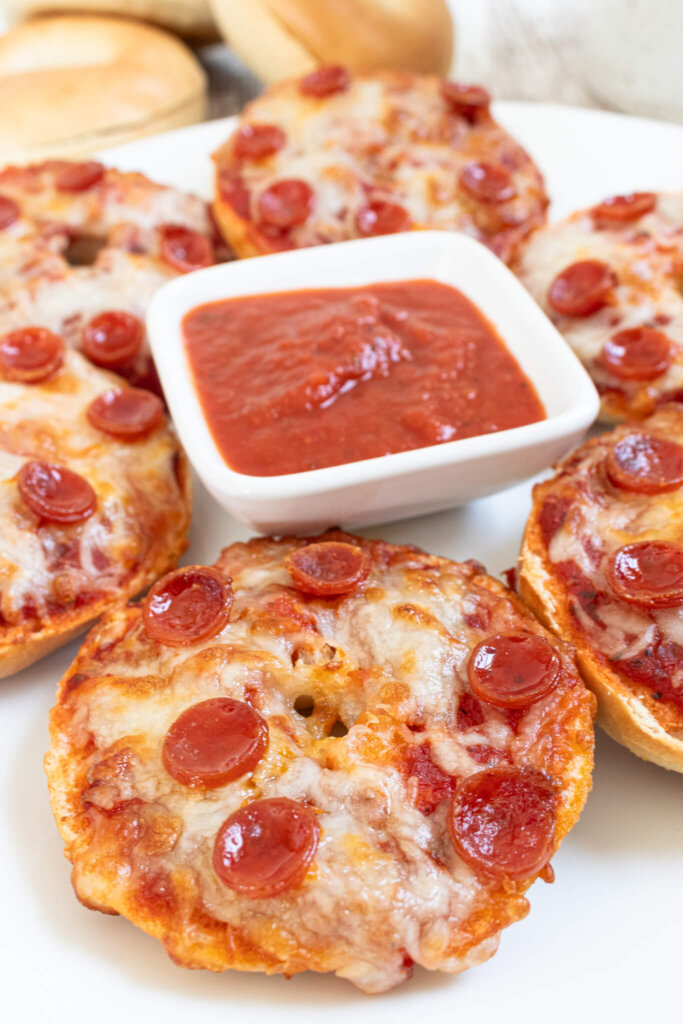 Mini pepperoni air fryer pizza bagels with tomato sauce in square dish