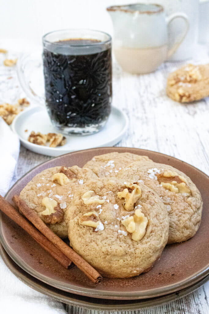 maple walnut cookies on brown plate with cinnamon sticks