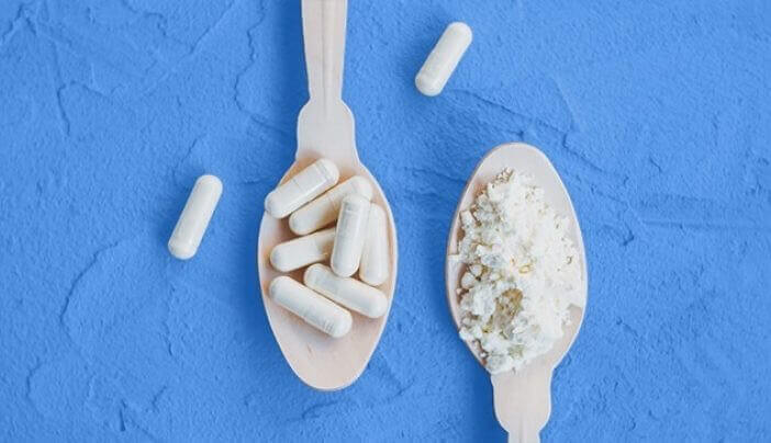colostrum pills and powder on white spoons