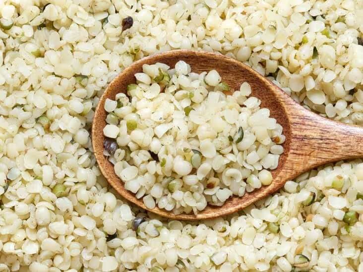 Hemp seeds in a bowl with wooden spoon