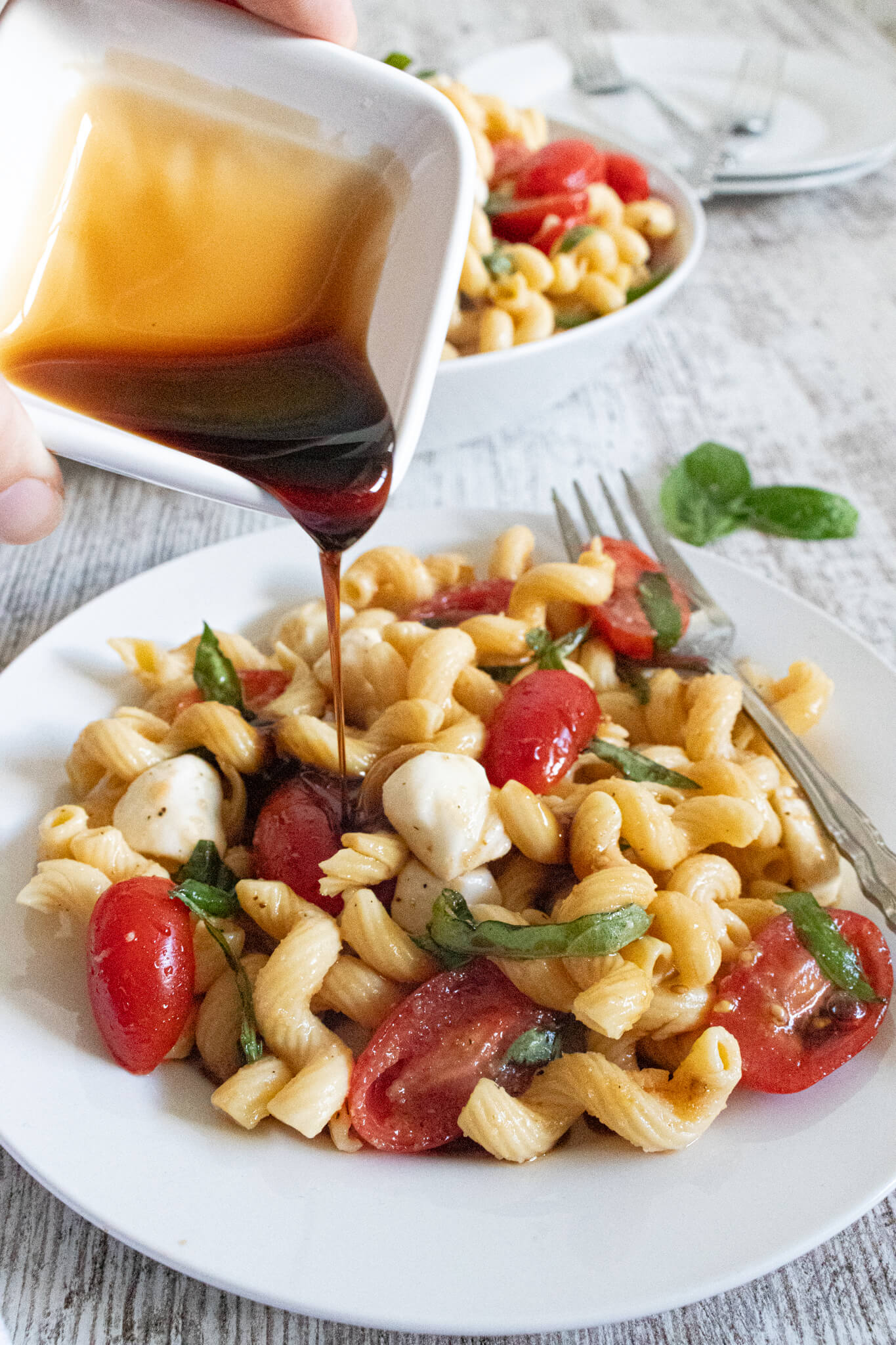 Pouring balsamic on pasta salad