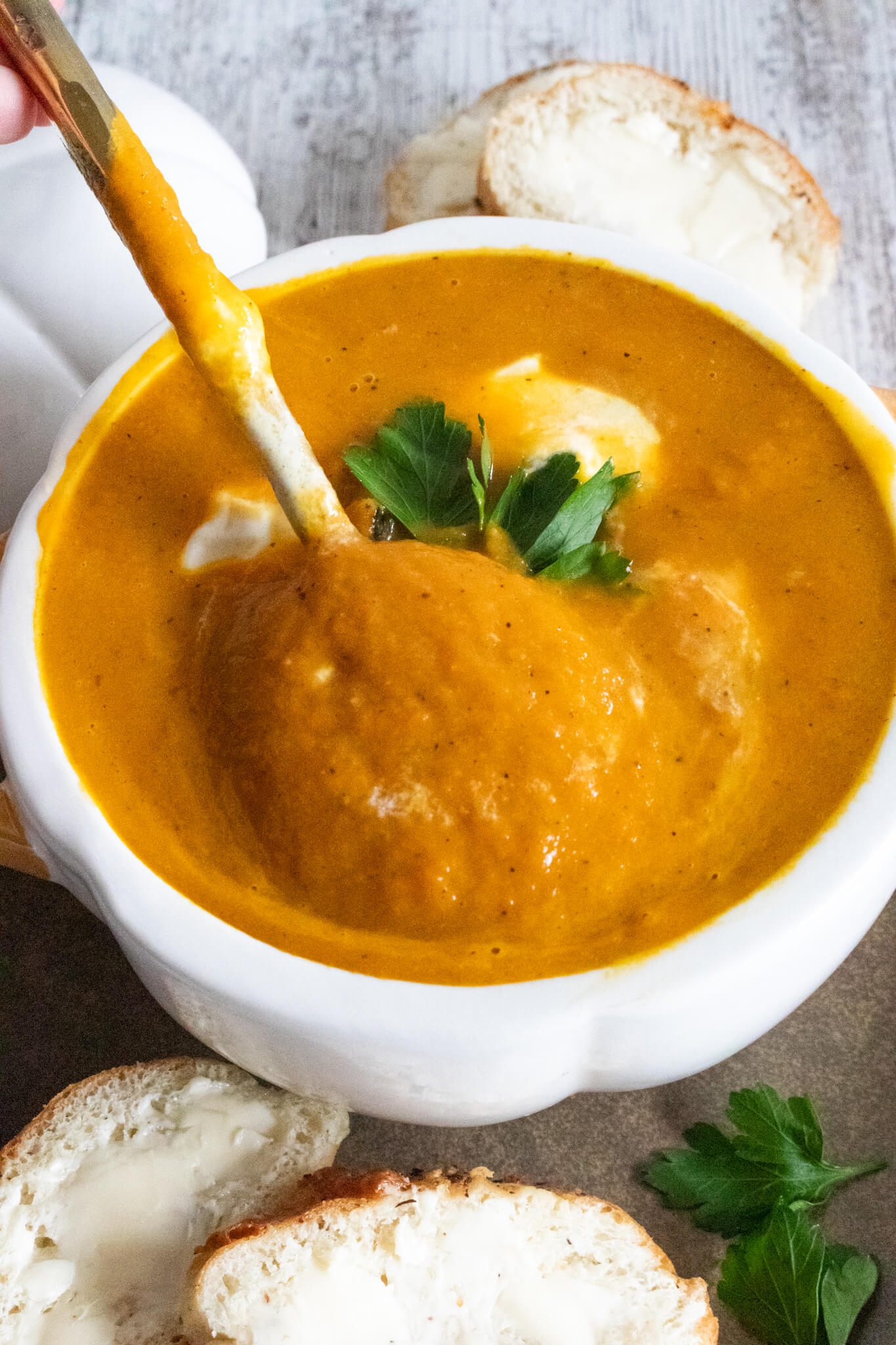 Pumpkin Carrot soup with a golden spoon coming out