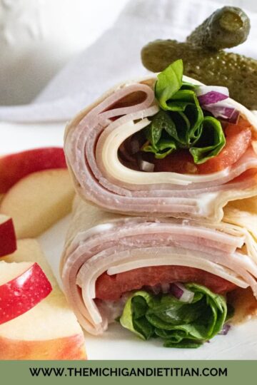Ham and cheese wrap with lettuce, tomato, and red onion