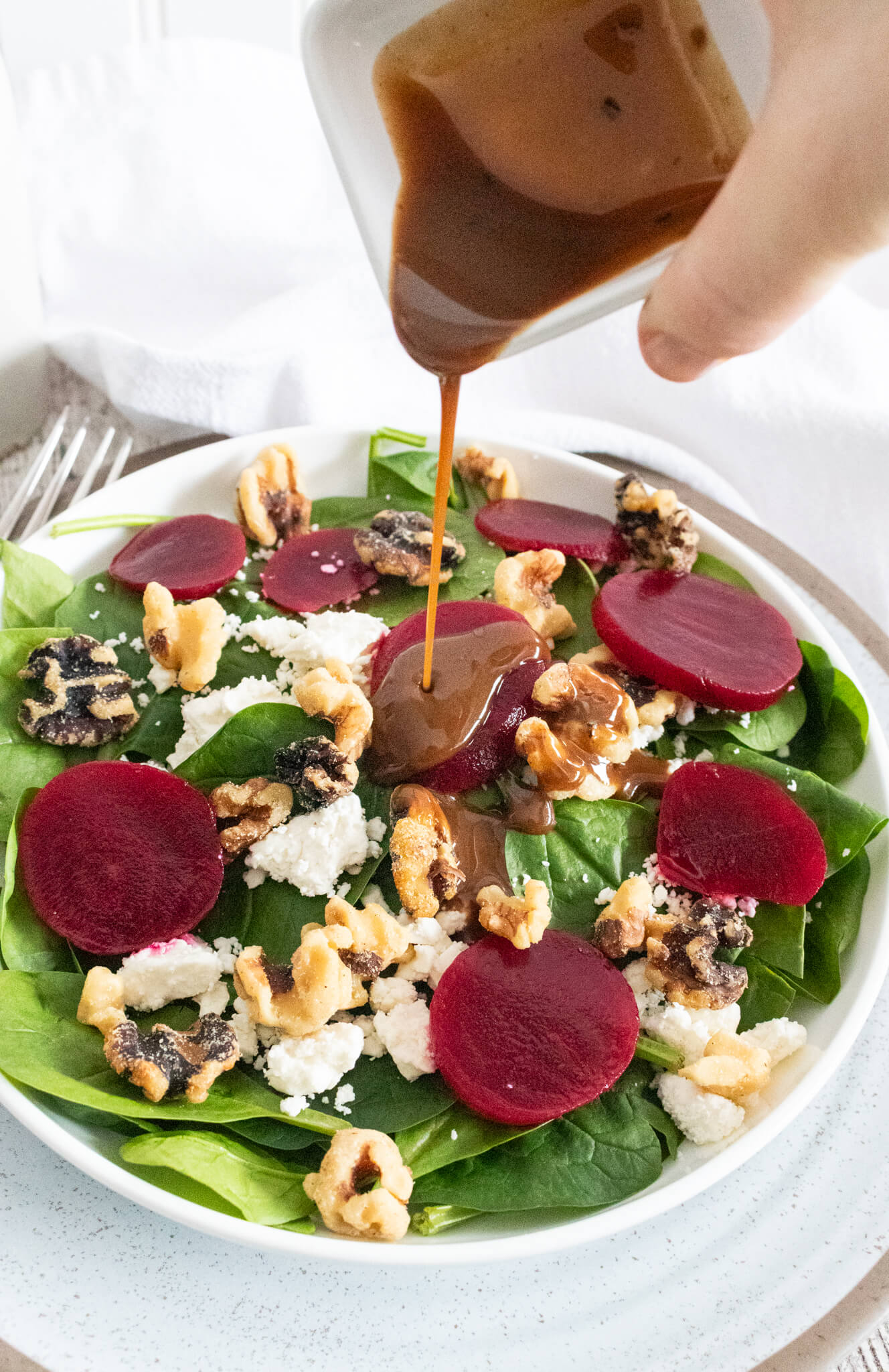 balsamic dressing pouring on beet salad