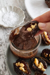 dip walnut stuffed dates in chocolate