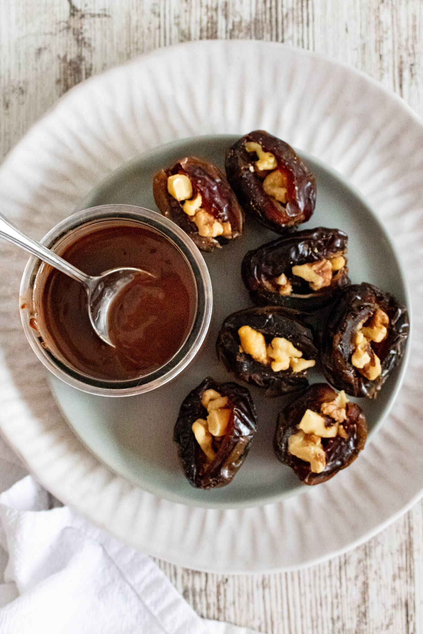 Stuffed dates on plate with melted chocolate