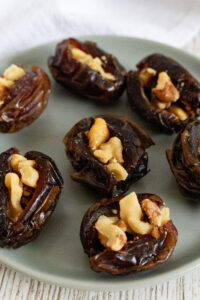 Walnut stuffed dates on gray plate